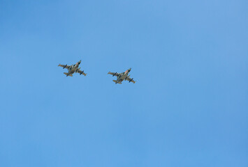 Fototapeta na wymiar Military aircraft SU25 flying in the blue sky