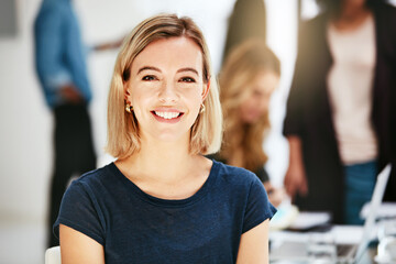 Happy, smiling and confident business woman sitting in a modern office, workspace or workplace. Portrait of a cheerful, joyful and blonde female corporate professional working at a startup company - obrazy, fototapety, plakaty