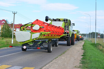 line of combine harvesters going forward on the road, close-up