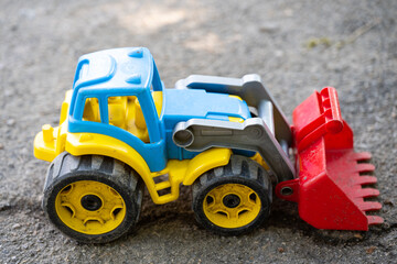 children's toy car excavator on asphalt