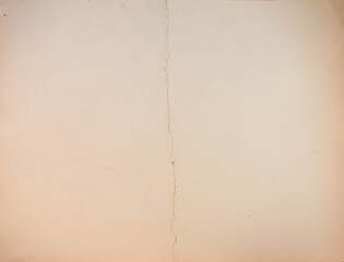 Texture of old yellowed cardboard paper with a big bend in the middle, old crumpled paper background