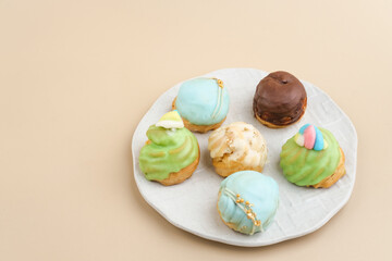 Choux pastry contains butter, water, flour, and eggs. Colorful choux with chocolate glaze.