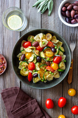 Pasta farfalle with tomatoes, zucchini, peas, Kalamata olives and sage. Healthy eating. Vegetarian food.