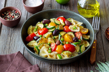 Pasta farfalle with tomatoes, zucchini, peas, Kalamata olives and sage. Healthy eating. Vegetarian...