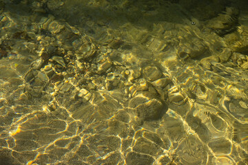 Water mountain river texture. Full frame. Fashionable light beige iridescent color of pure water. Iridescent sun and stones. Abstract natural background. Layout for wallpapers, postcards, banners.