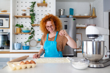 Baking Concept. Portrait Of Joyful Woman Kneading Dough In Kitchen Interior, Cheerful Female In Apron Having Fun While Preparing Homemade Pastry,