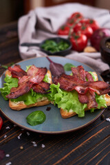 bacon and cream cheese sandwiches on a plate on wooden table at domestic kitchen