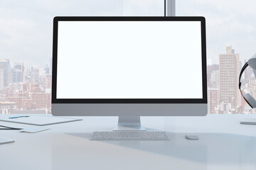 Close up of designer desktop with empty white mock up computer monitor laptop and supplies in modern office with window and panoramic city view. 3D Rendering.
