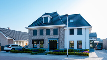 Dutch Suburban area with modern family houses, newly build modern family homes in the Netherlands, dutch family houses in the Netherlands, newly build streets with modern houses.  - obrazy, fototapety, plakaty