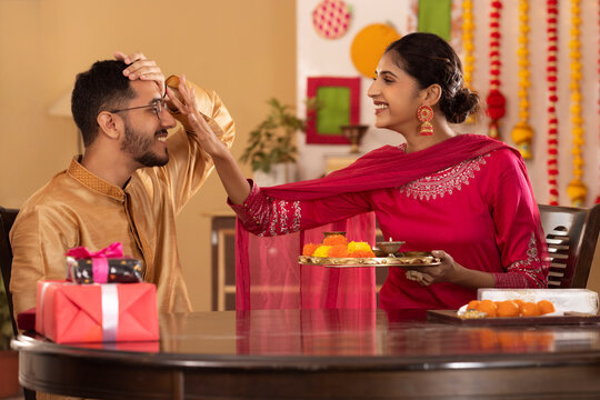 Sister applying tika on her brother's forehead on the occasion of Raksha Bandhan