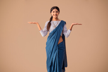 Portrait of a woman model gesturing against plain background