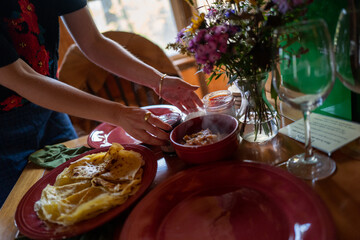 closeup of home chef plating steaming apple compote and crepes
