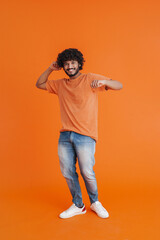 Fototapeta premium Young indian handsome curly smiling man dancing