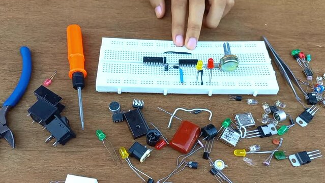man hand making electrical circuit on bread board 