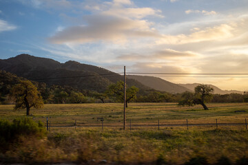 beautiful scene of golden hour light spilling over hills and cattle range in central California