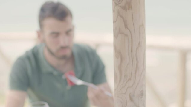 4K SlowMo - Young couple (20-25 years old) having a date in a restaurant gazebo overlooking the beach - cuddling, eating assorted raw tuna, drinking wine, toasting