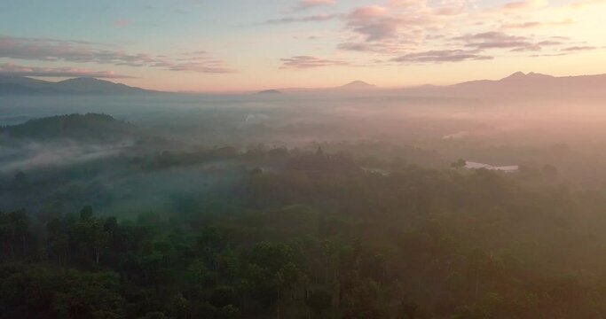 birds eye view over the borobudur temple indonesia and the surrounding mountains in an orange sunrise