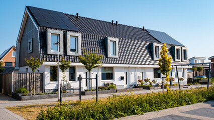 Newly build houses with solar panels attached on the roof against a sunny sky Close up of a new...