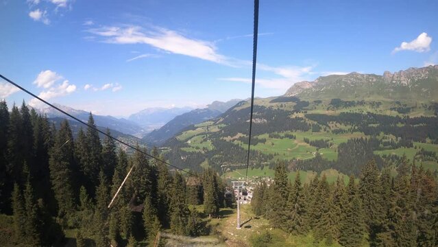 Cable car ride in canton Grisons Churwalden. View from a cable car on the beautiful nature in Switzerland. The ropeway descends into the valley