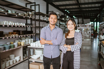 Fototapeta na wymiar Asian man and woman standing with hands crossed in home improvement store
