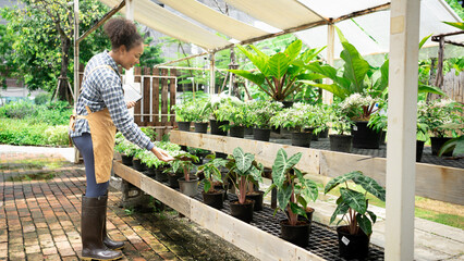 Portrait of beautiful women owner standing in own tree shop and smiling. African American females business partners working garden store. Business concept.Tablet quality control.Clip board.