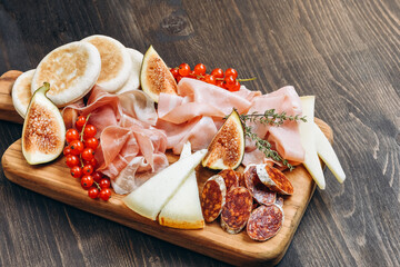 Food  prosciutto ham, salami, olives and  bread.  cheese on a board parmesan, pecorino. Charcuterie board.