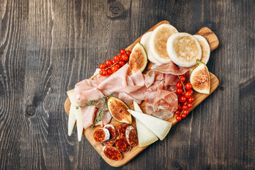 Food  prosciutto ham, salami, olives and  bread.  cheese on a board parmesan, pecorino. Charcuterie board.