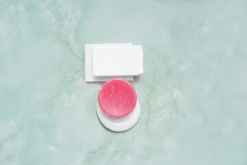 different bars of soap on green bathroom tile background, white and red soaps for daily cleansing