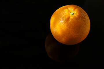 1 one Orange fruit. Close-up of oranges against black background. mirror reflection.