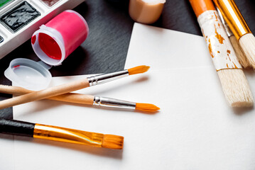 Few paint brushes and gouache tint can laying on work desk