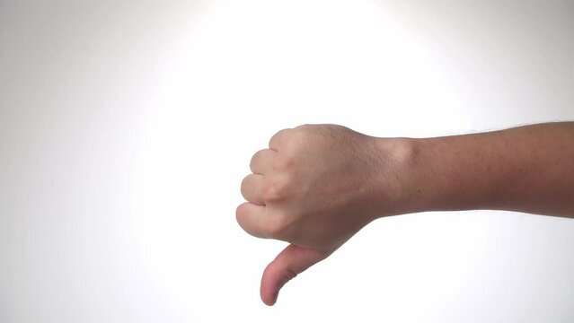 A man's hand shows dislike, thumb down on a white background