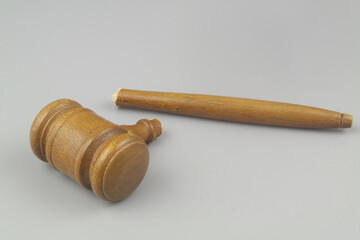 Lawlessness concept. Broken judge gavel on gray background.