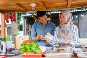 customer picking an order in traditional food market stall served by the seller