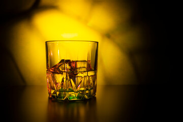 glass with ice on a colorful background