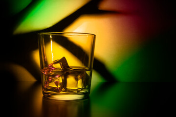 glass with ice on a colorful background