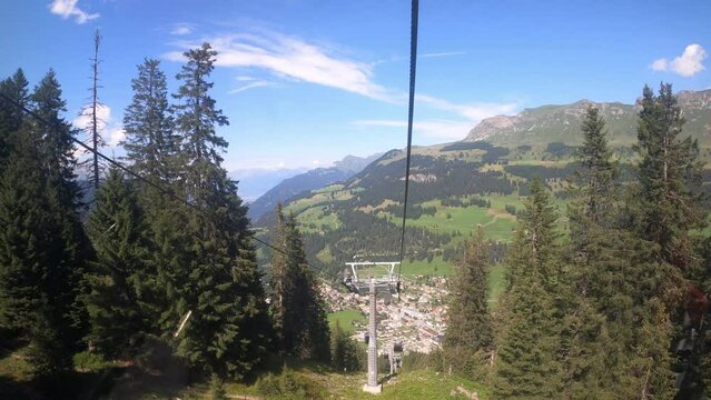 Cable car ride in canton Grisons Churwalden. View from a cable car on the beautiful nature in Switzerland. The gondola lift descends into the valley. You can see masts of the cable car