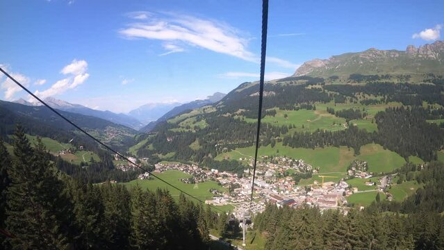 Cable car ride in canton Grisons Churwalden. The gondola lift descends into the valley. You can see the small village in the valley.
