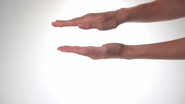 Women's hands - palm gesture shows height, increases and decreases the distance between the palms on a white background