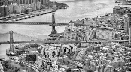 New York City from helicopter point of view. Brooklyn and Manhattan Bridges with Manhattan skyscrapers on a cloudy day