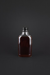 Iced cold brew coffee in blank label on glass bottle isolated black background. Arabica, ready to drink