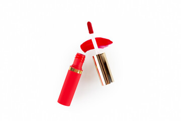 drop of red liquid lipstick smeared on a white background. Red lip gloss in a tube with an applicator isolated on a white background