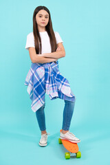 Fashion teenage lifestyle, beautiful teen girl with skateboard isolated on studio background.