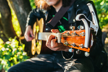Man playing acoustic guitar and playing chords close-up