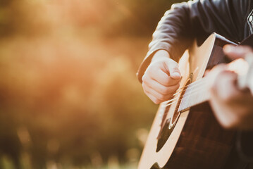 Man playing guitar in nature on a sunny day