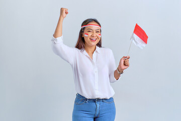 Excited young Asian woman celebrate Indonesian independence day holding the Indonesian flag isolated on white background