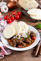 Czech traditional recipe for goulash with homemade dumpligs, served in simple rustic style