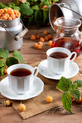 Flavored raspberry tea. Vitamin hot steaming drink with natural berries on wooden table