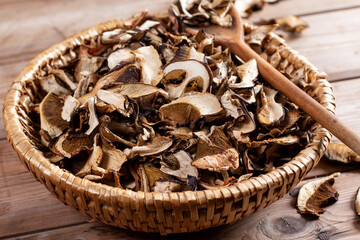 Dried mushrooms sliced, on a plate on wooden background
