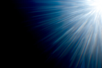 Powerful lens flare. Blue flare with rays on dark background.