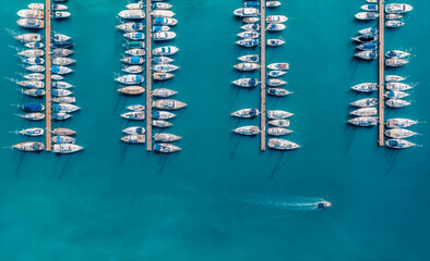 Aerial view of luxure yachts and motorboats moored in a port with clear blue water in summer. Top...